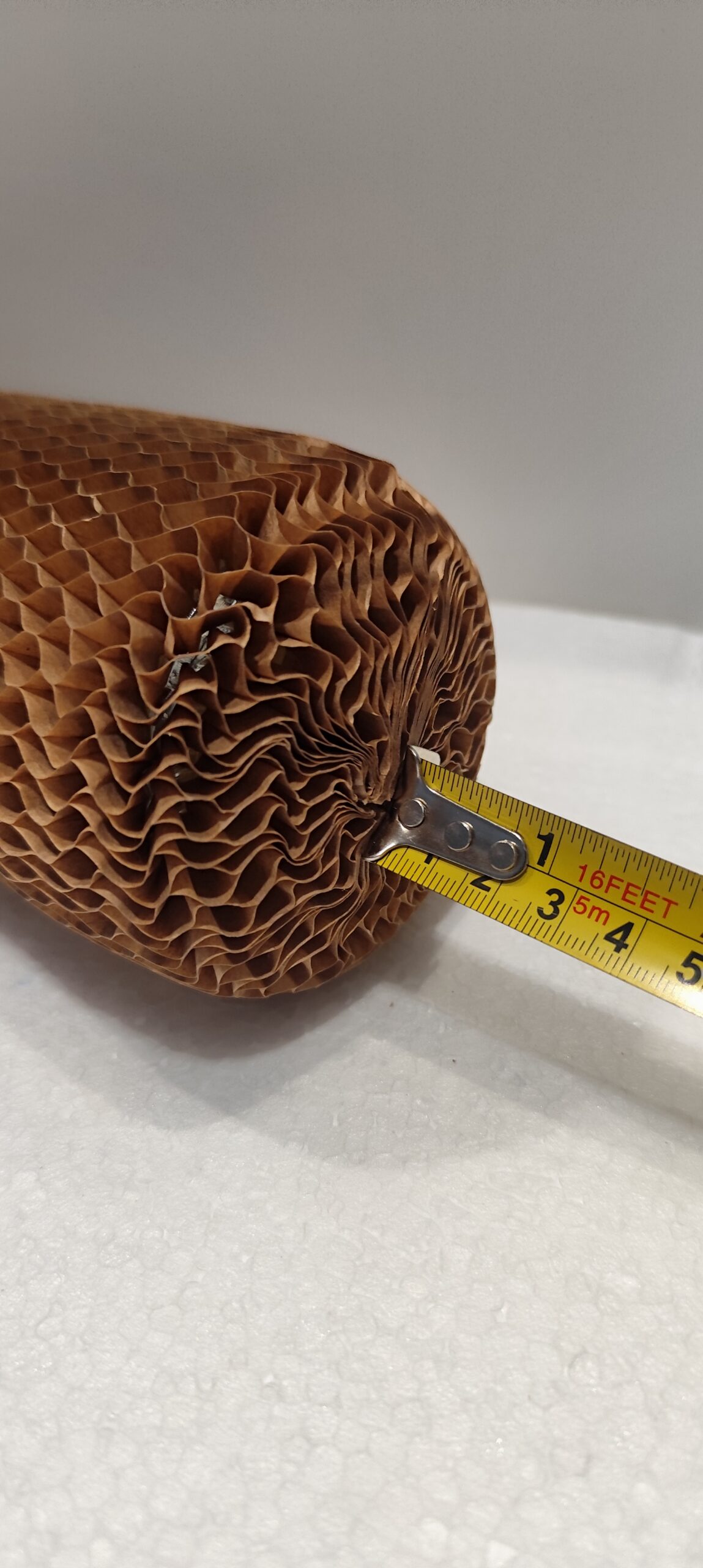 Rękaw papierowy 35 cm 70 g/m² do butelek – plaster miodu, oczko 8 mm – ekologiczne pakowanie bez plastiku Zbliżenie na dno szklanej butelki zabezpieczone rękawem papierowym plaster miodu 35 cm, kraft 70 g/m², oczko 8 mm.